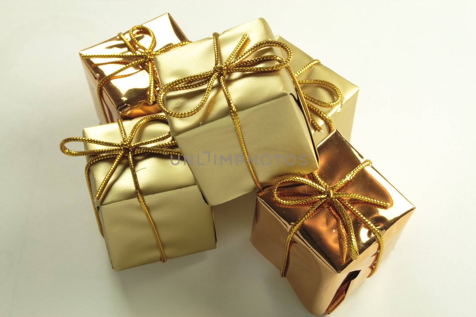 five gold presents tied with golden string