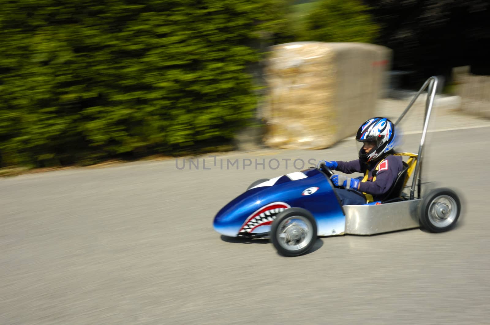 A competitor in a soap-box derby championship hurtles down the road.
