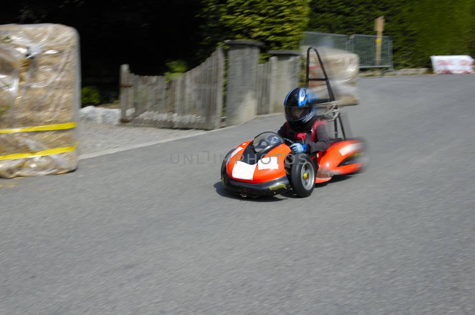 A competitor in a soap-box derby championship hurtles down the road.