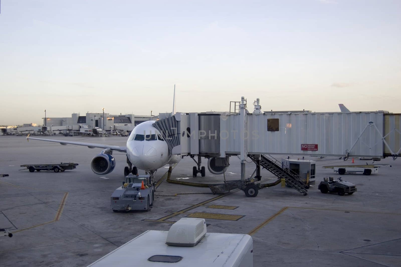 Airport Scene Showing airplane and different tractors and jet bridge
