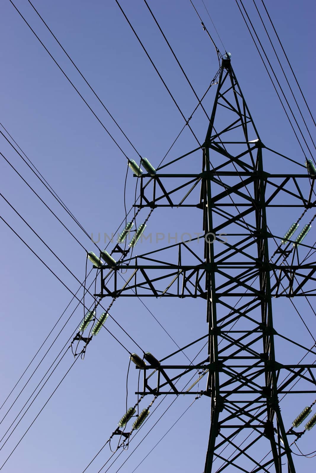 Green high voltage electric line against blue sky