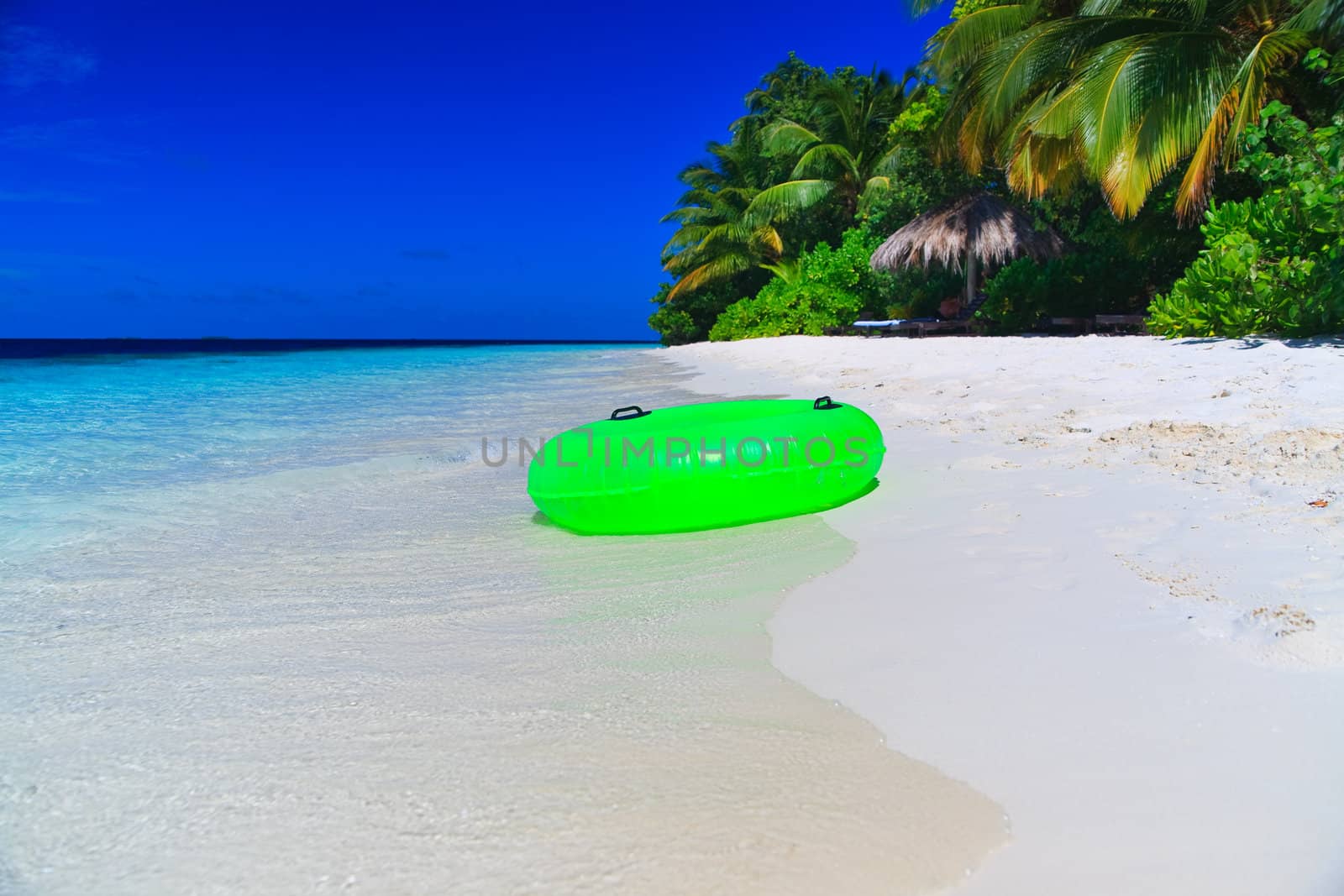 Green Swim Ring on empty beach at Maldives
