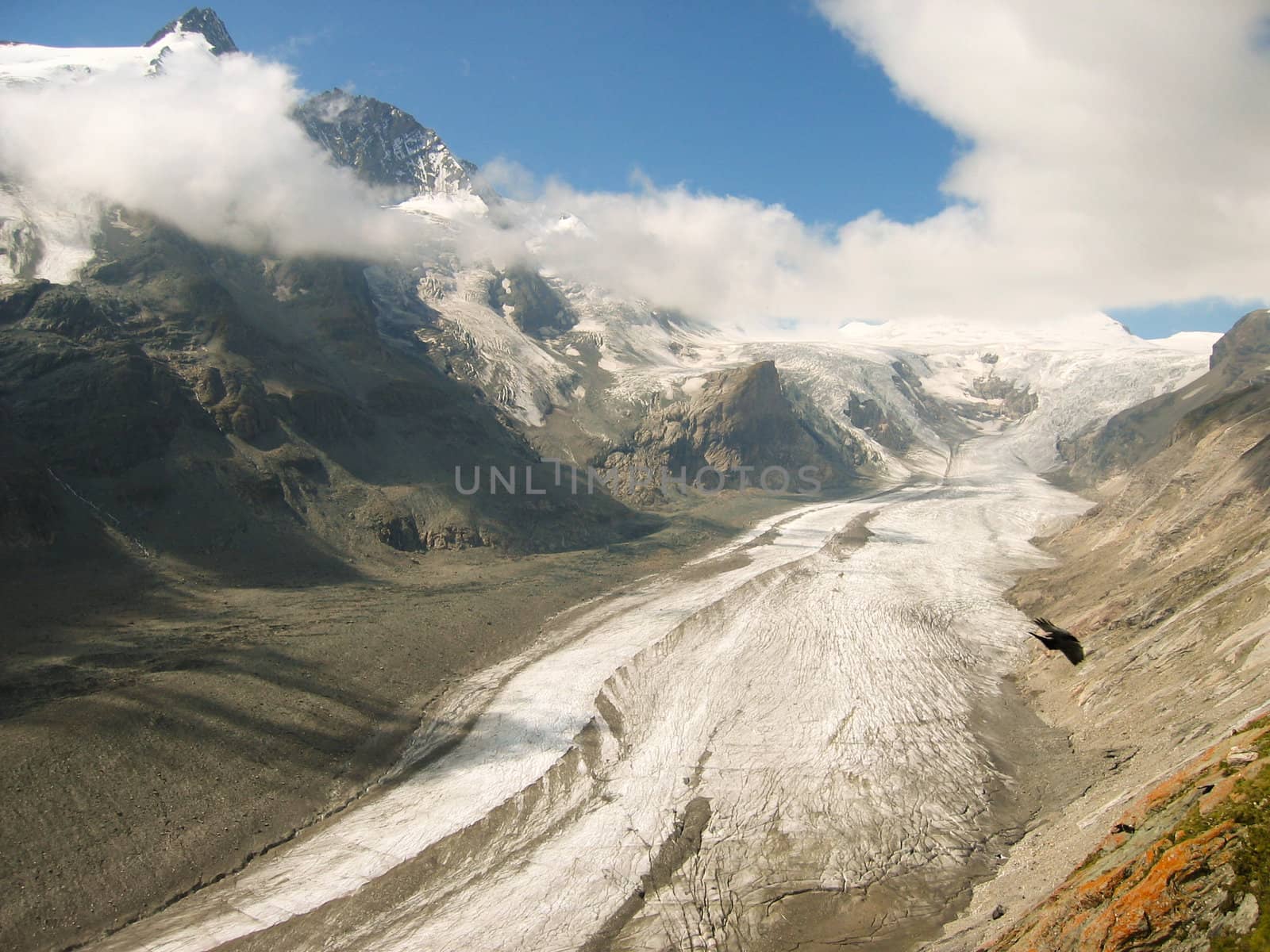 glacier vally with top covered in  fluffy clouds