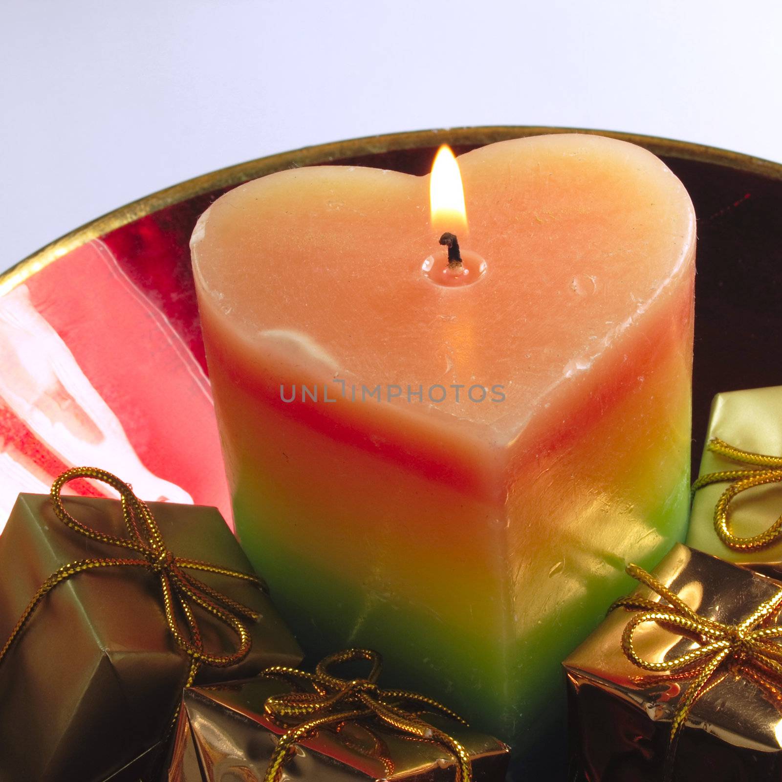 heart candle and presents in a red glass bowl by leafy
