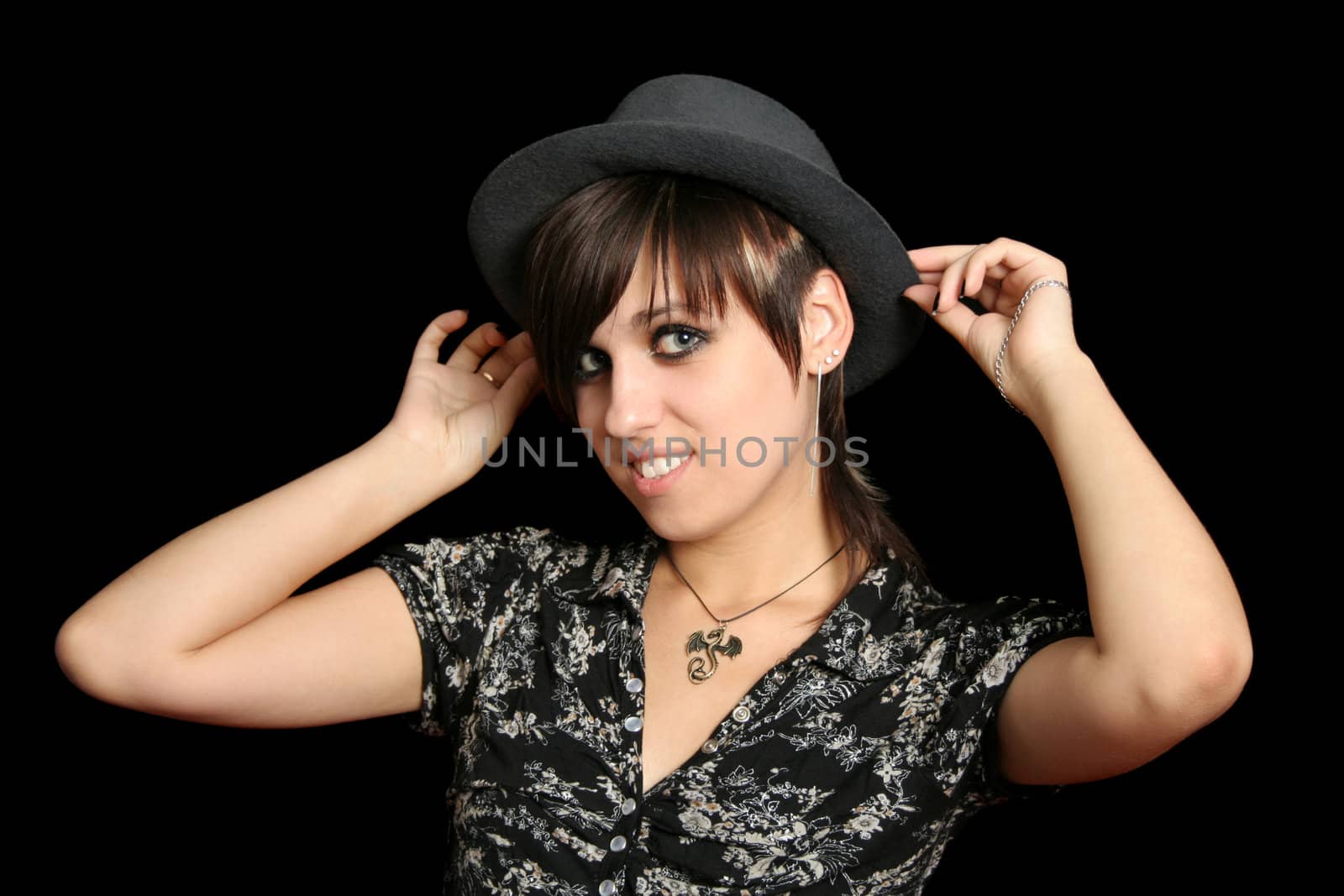 The young smiling girl in a hat, on a black background