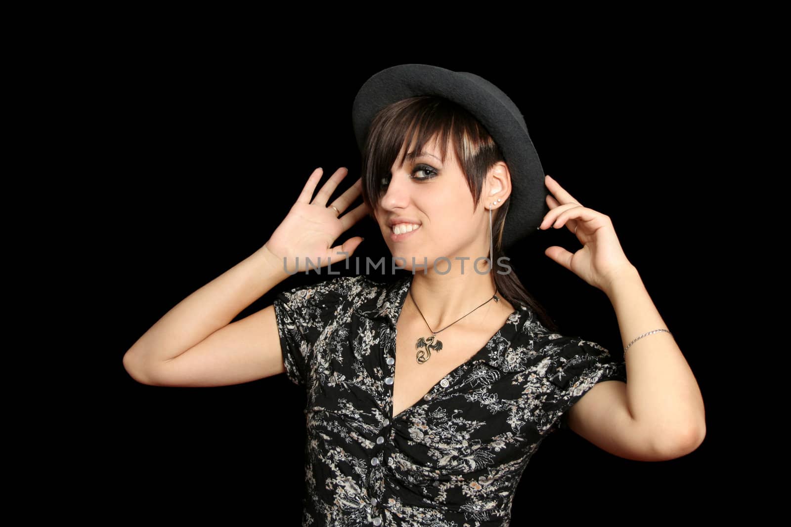 The young smiling girl in a hat, on a black background