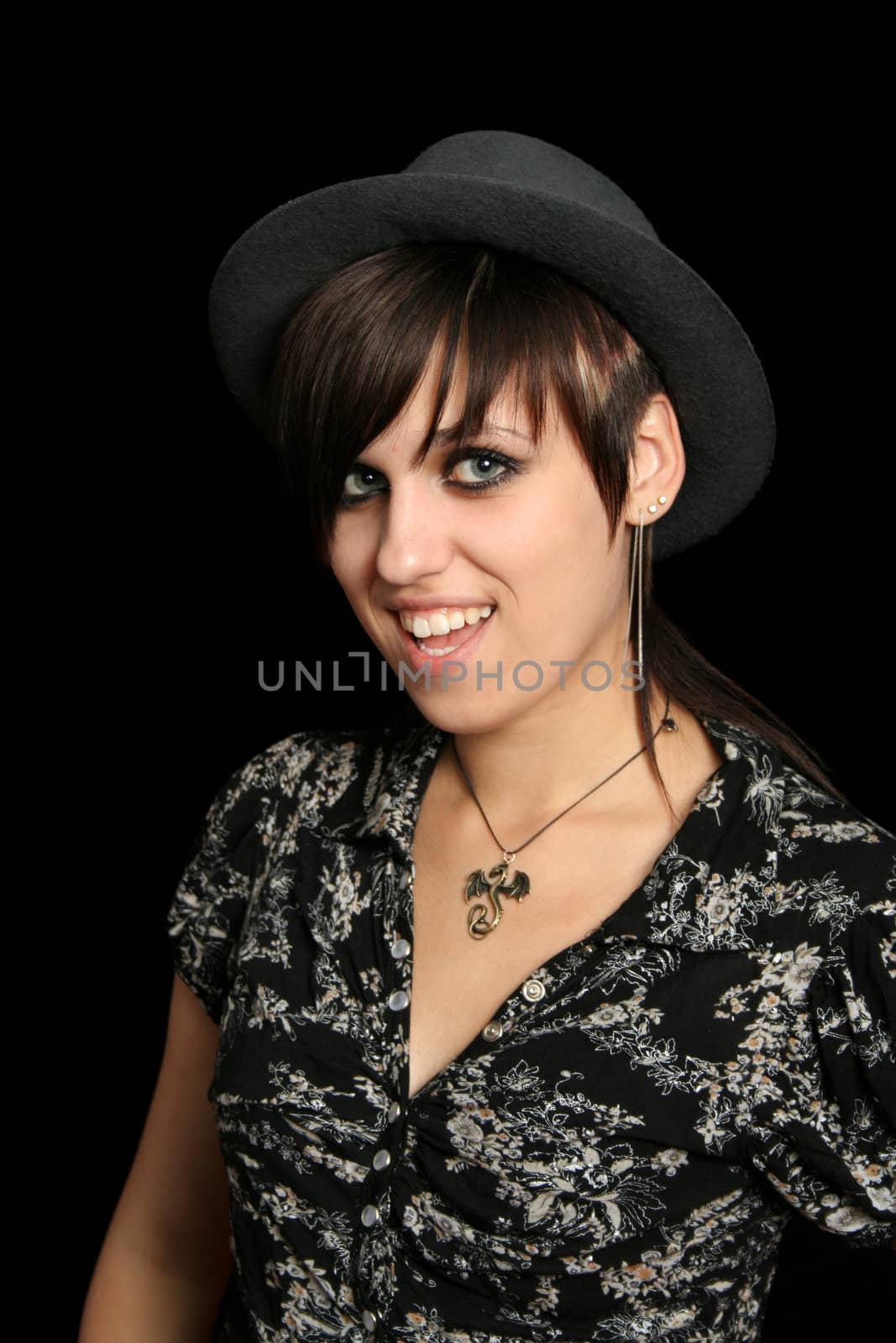 The young smiling girl in a hat, on a black background