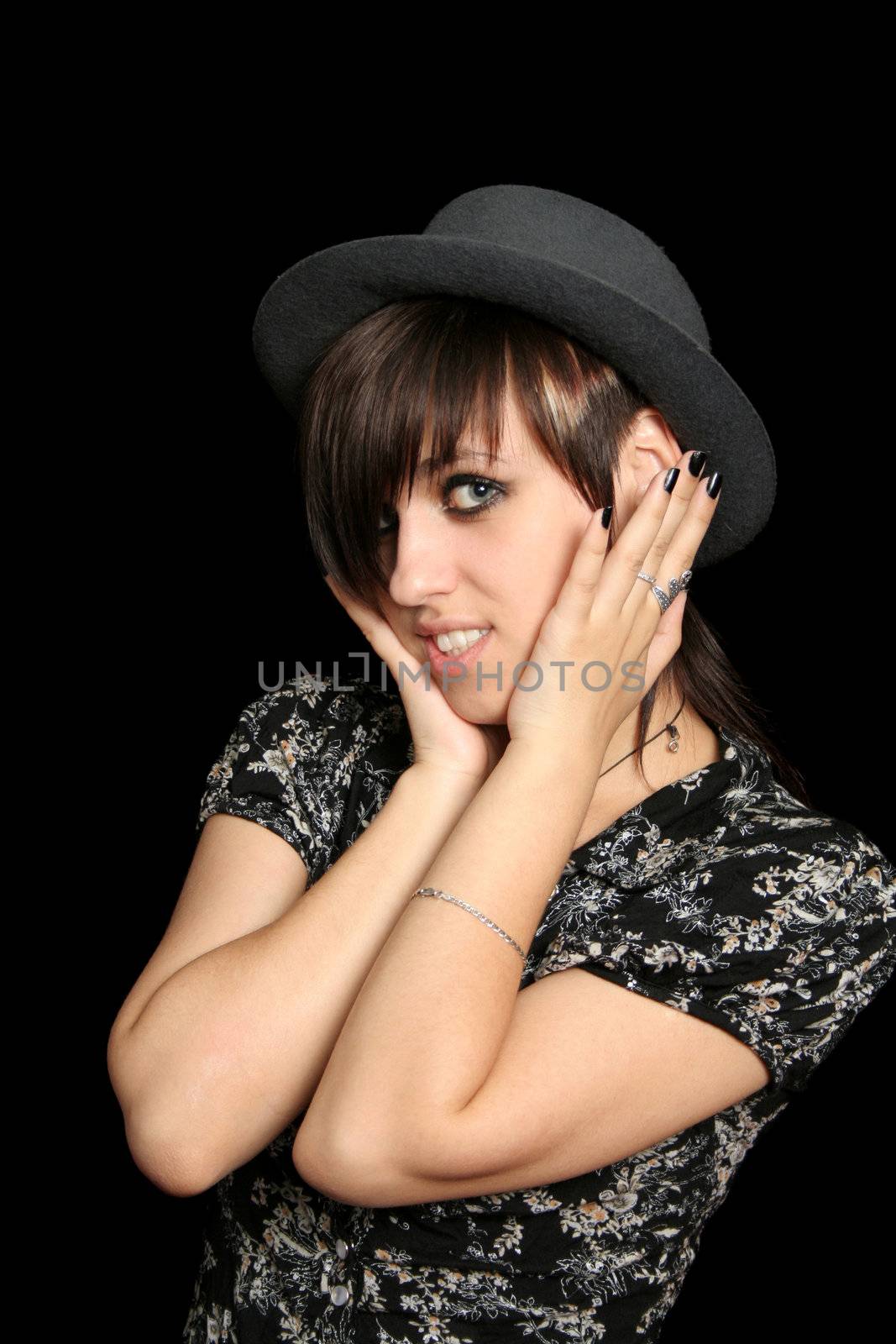 The young smiling girl in a hat, on a black background