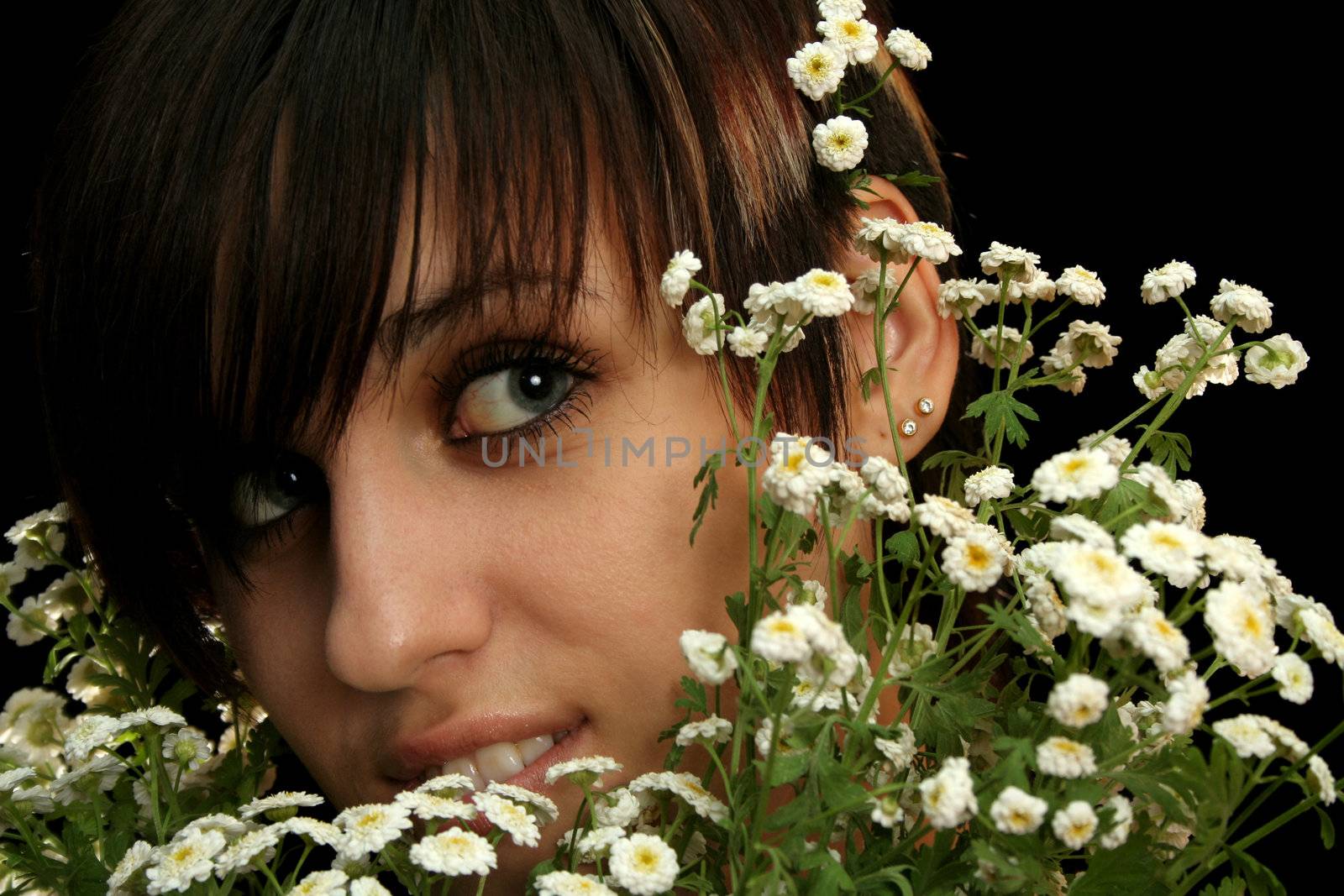 The young beautiful girl with flowers, isolated on a black background