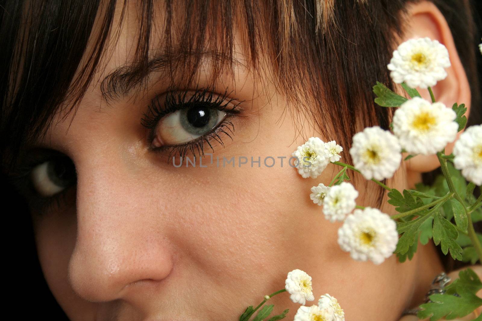 The young beautiful girl with flowers, isolated on a black background