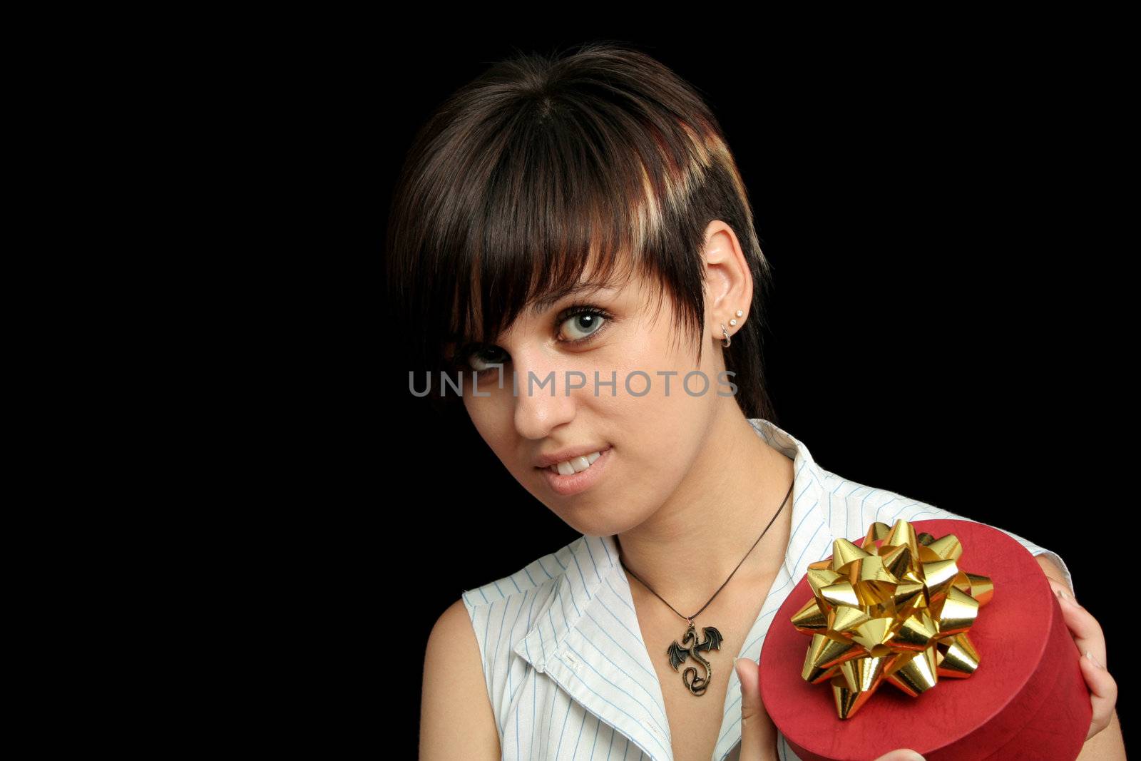 The young girl holds a box with a gift, isolated on black background