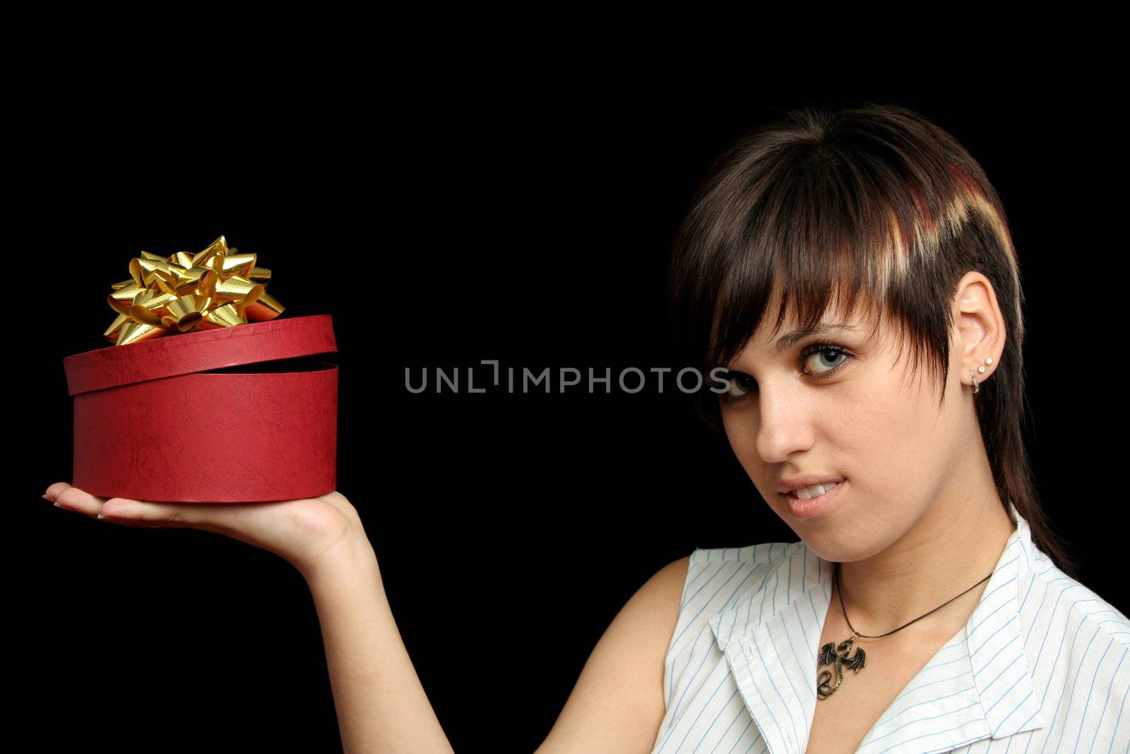 The young girl holds a box with a gift, isolated on black background