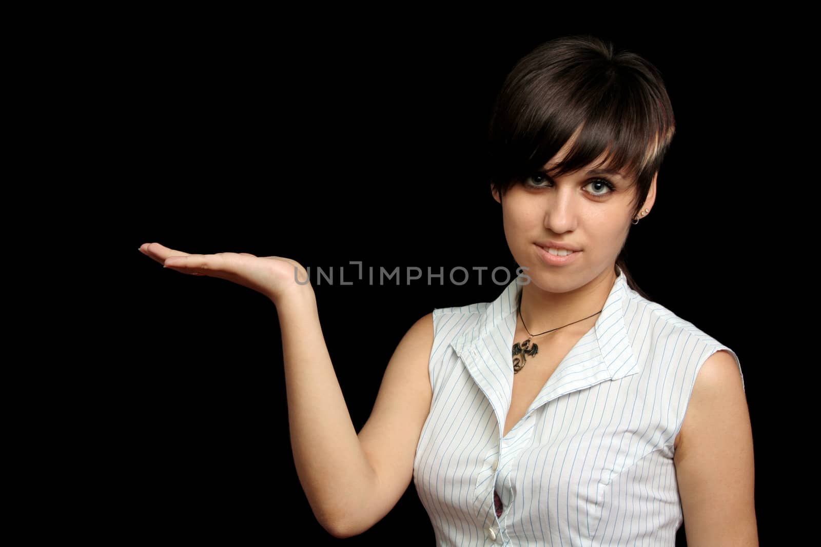 The young girl holds something in a hand, is isolated on a black background