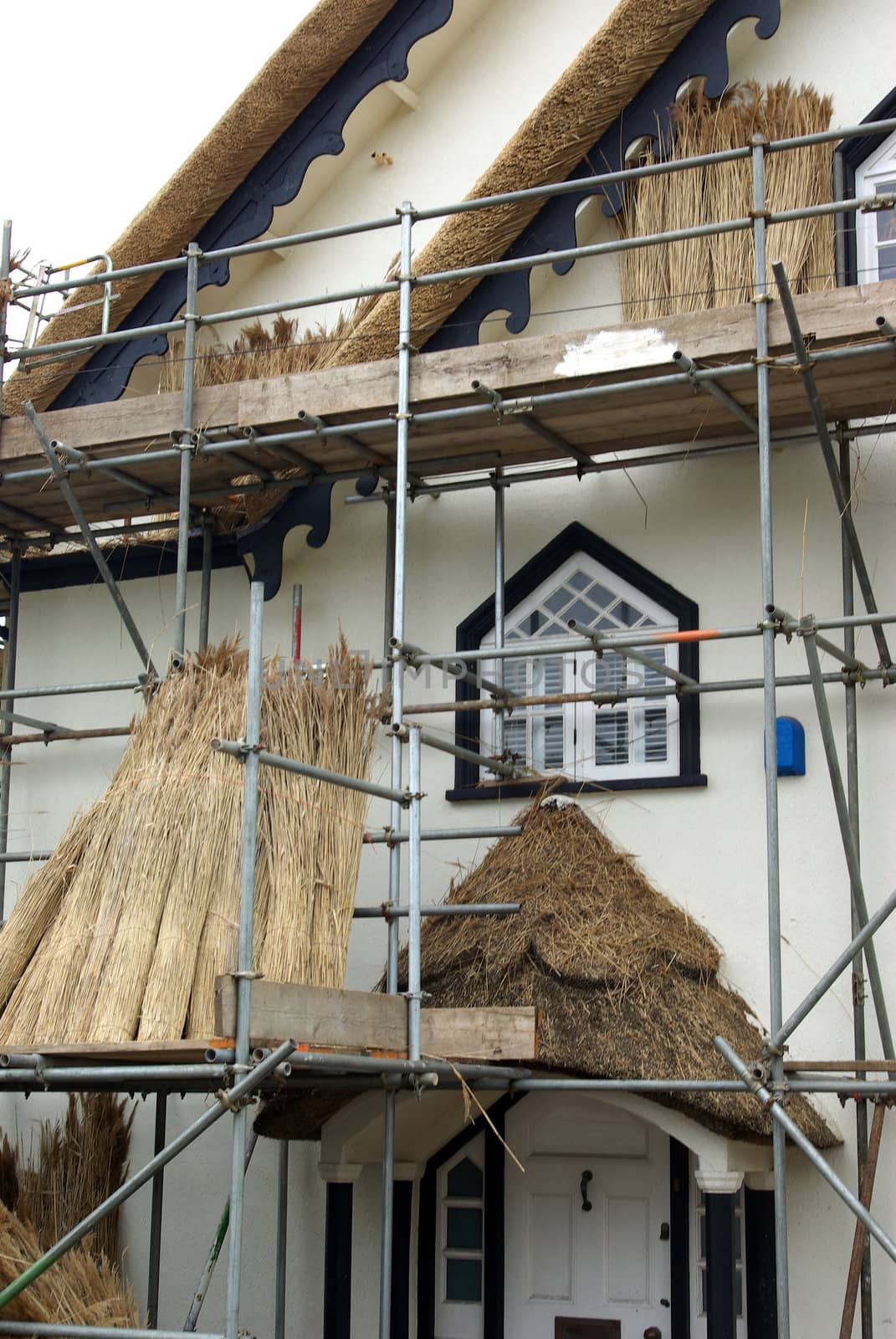 Photo of a thatched-roof house that is being built