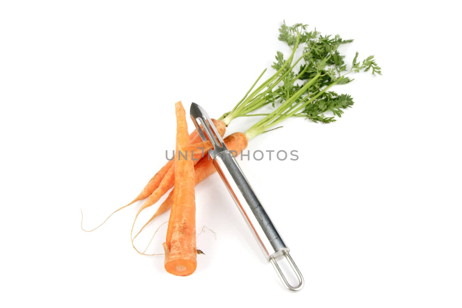 Bunch of raw carrots with chrome peeler on a reflective white background