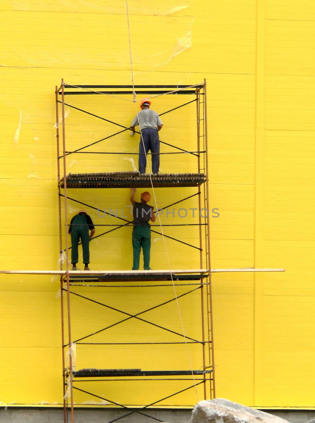 Three workers on scaffolding