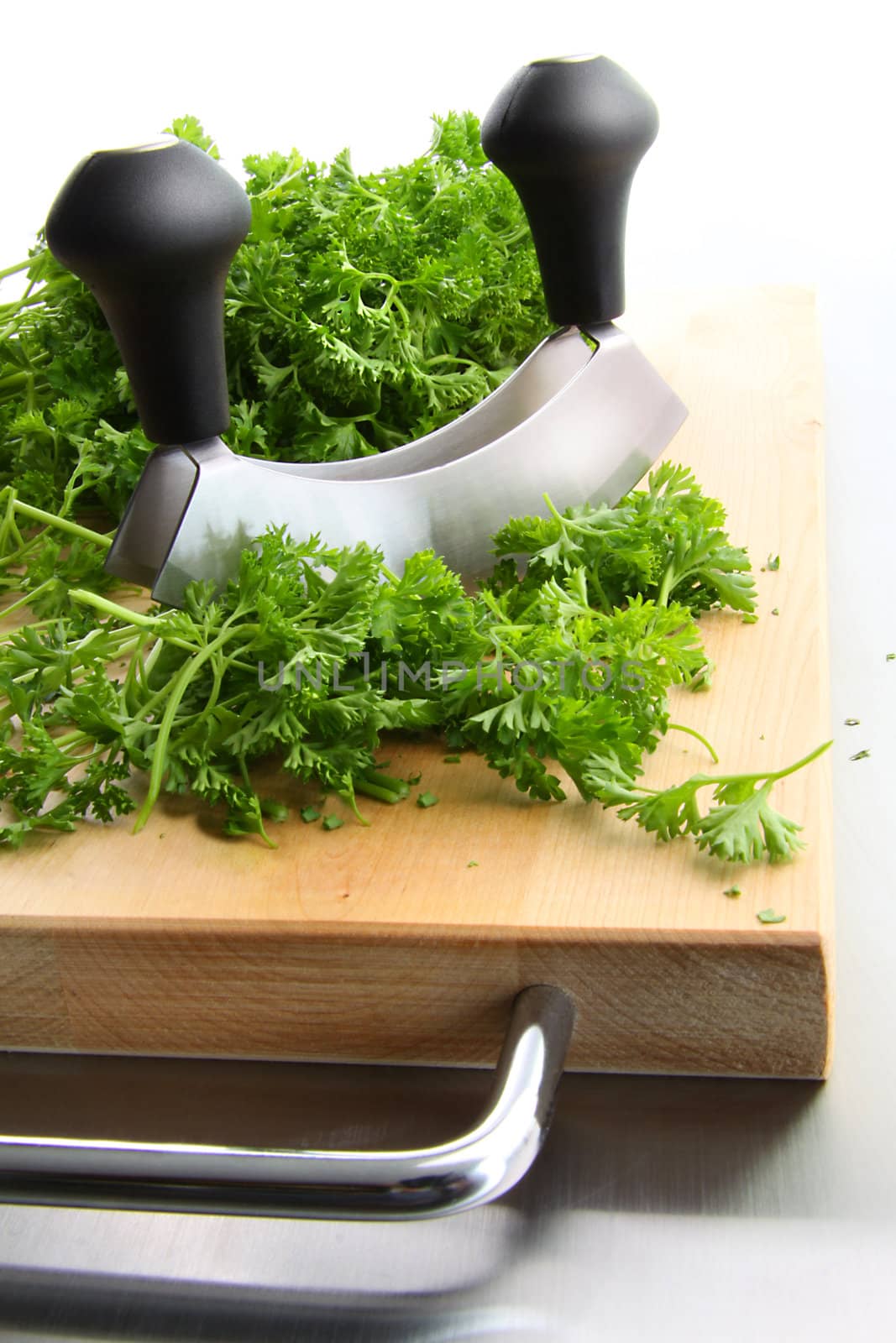 Freshly chopped parsley on wooden cutting board