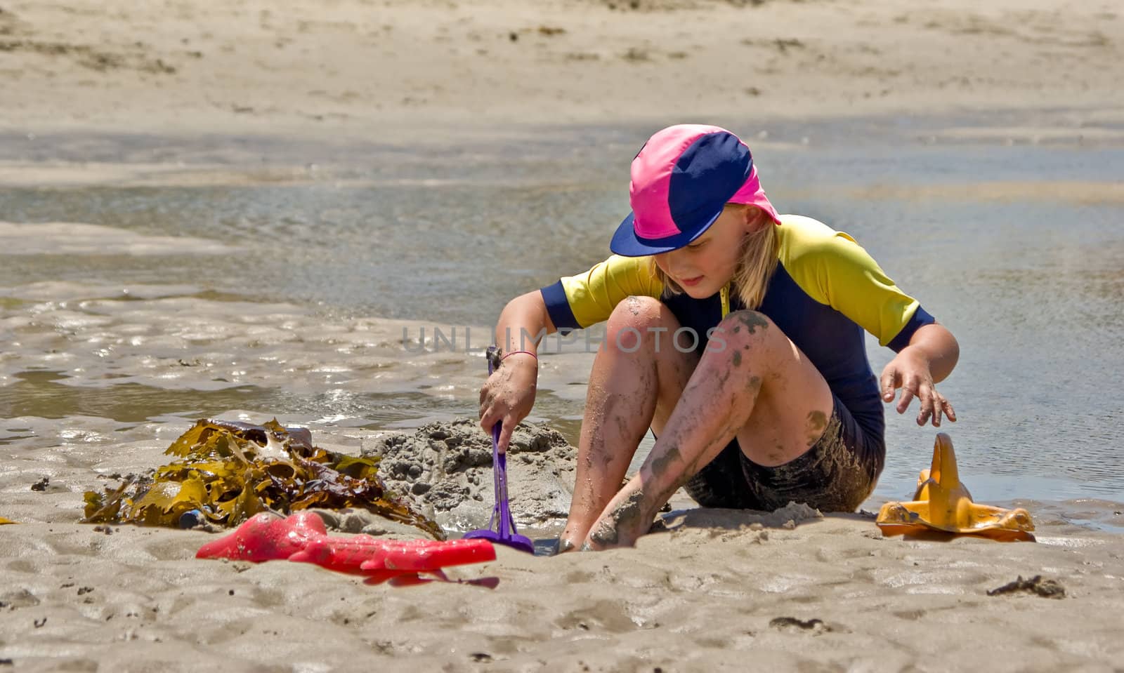 girl playing in sand at beach by clearviewstock