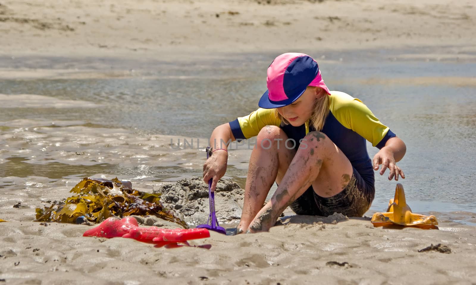 girl playing in the sand at the beach