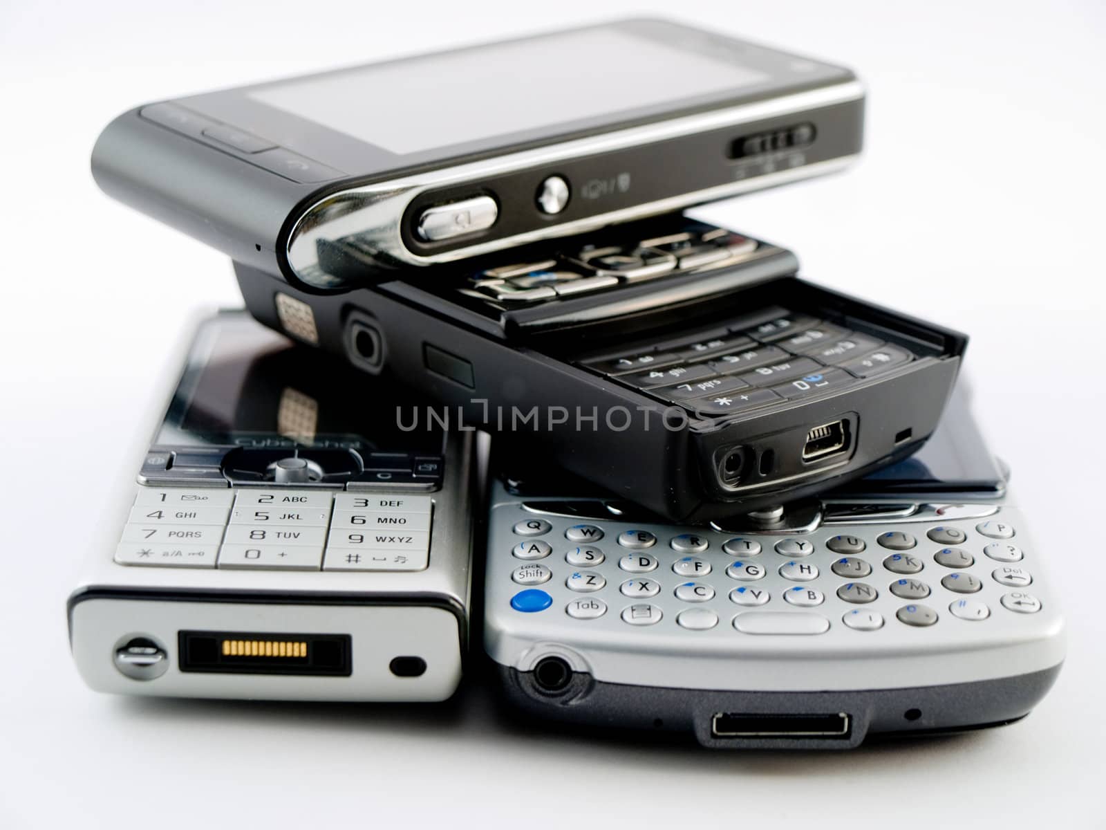 Stack Pile of Several Modern Mobile Phones PDA Cell Handheld Units Isolated on White Background