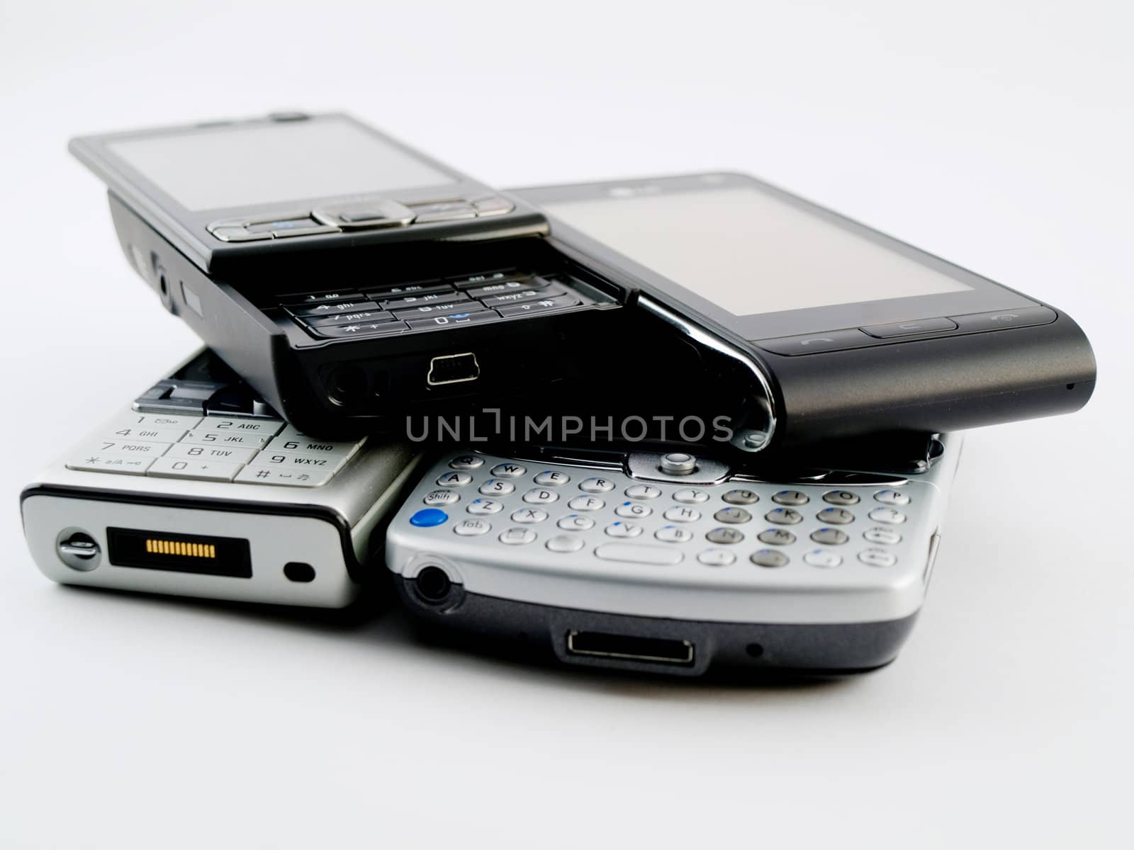 Stack Pile of Several Modern Mobile Phones PDA Cell Handheld Units Isolated on White Background