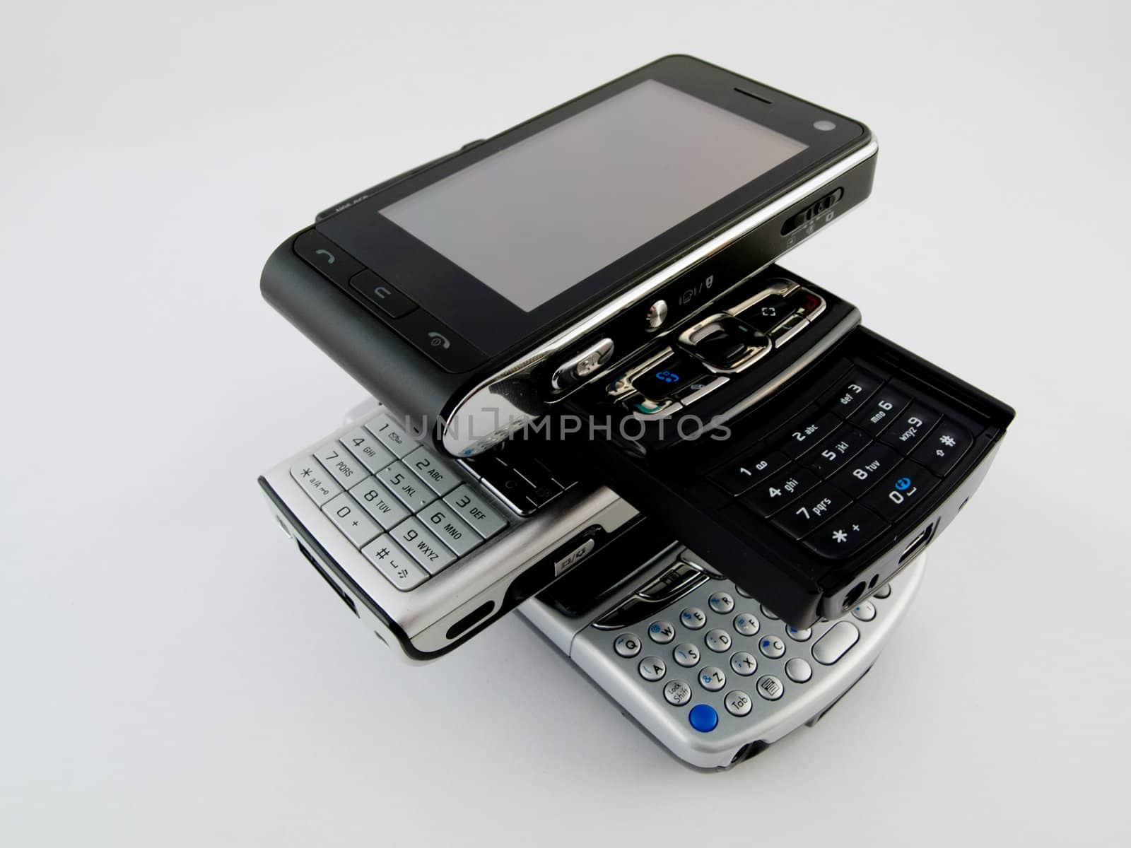 Stack Pile of Several Modern Mobile Phones PDA Cell Handheld Units Isolated on White Background