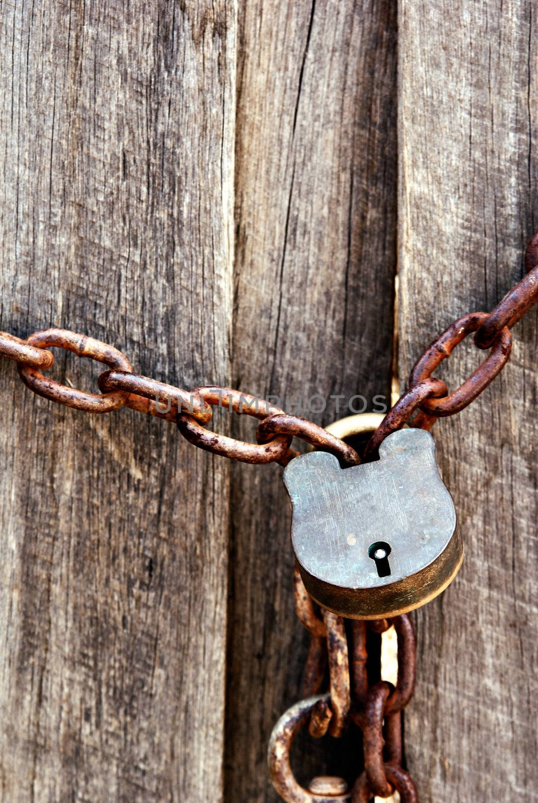 old lock and chain around wooden fence