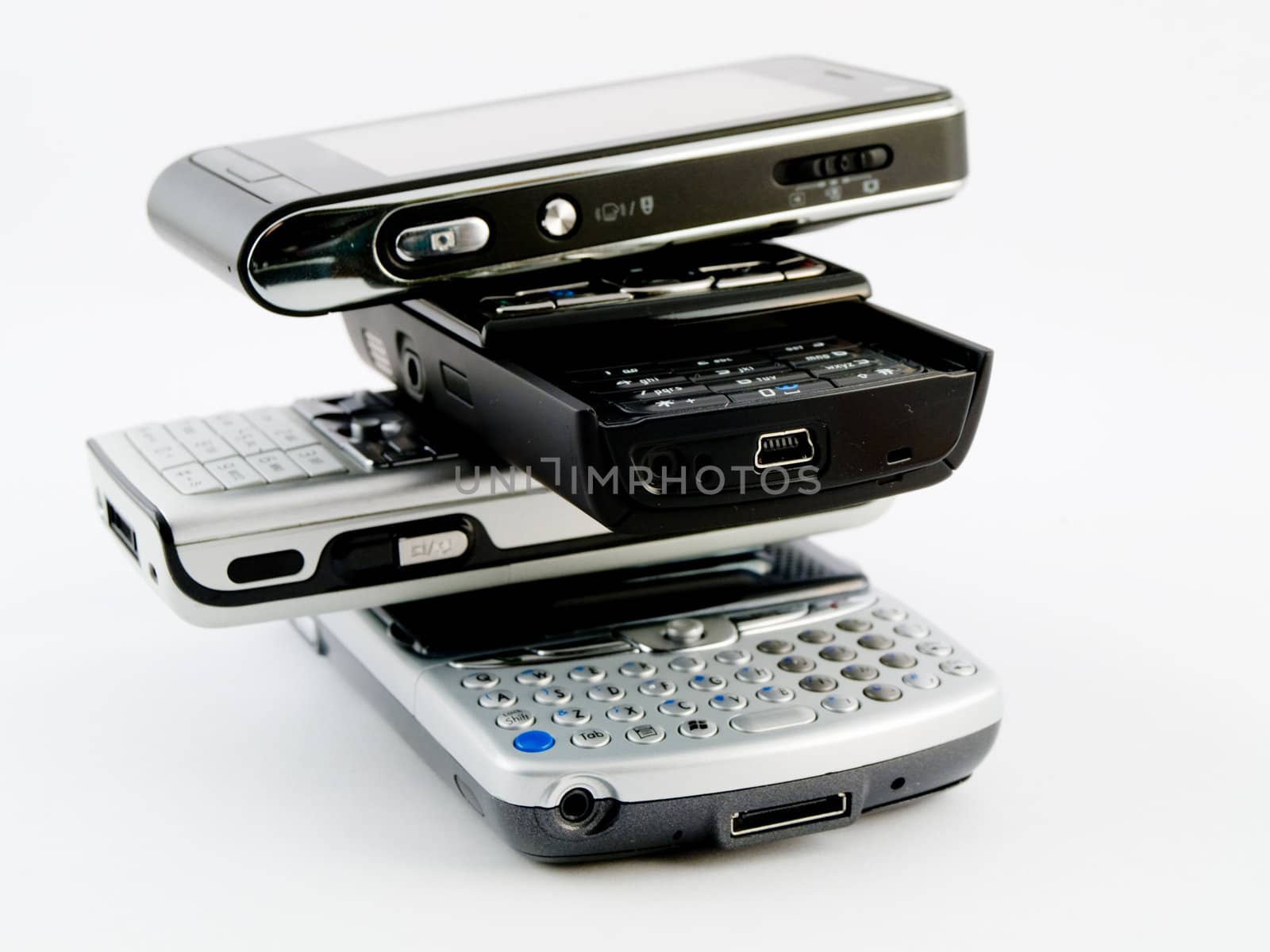 Stack Pile of Several Modern Mobile Phones PDA Cell Handheld Units Isolated on White Background