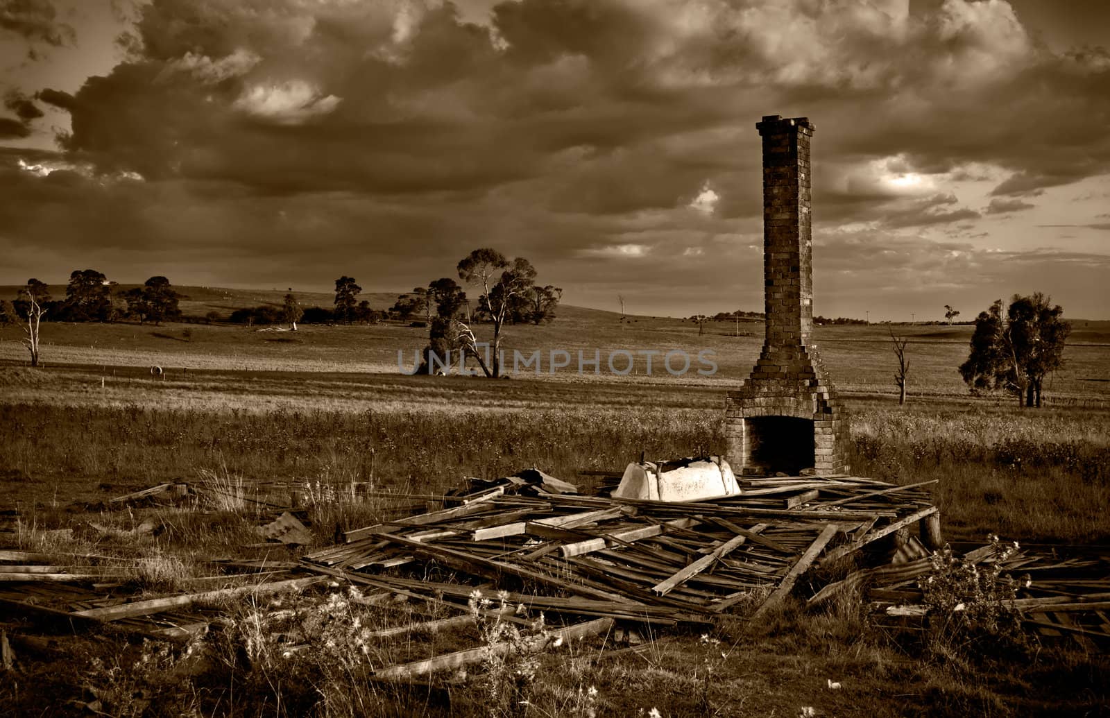 huff n puff - sepia image of when a dark storm comes over the fallen down ruins on the farm