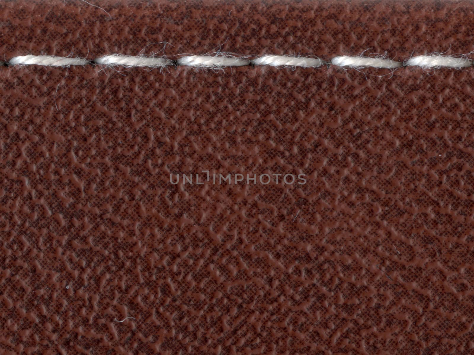 straight white stitch over the leather material surface