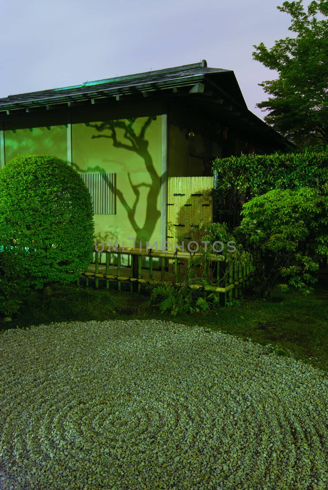 Japanese house wall with tree shadow and traditional circle pattern on the sand in zen garden by night time, Tokyo Japan