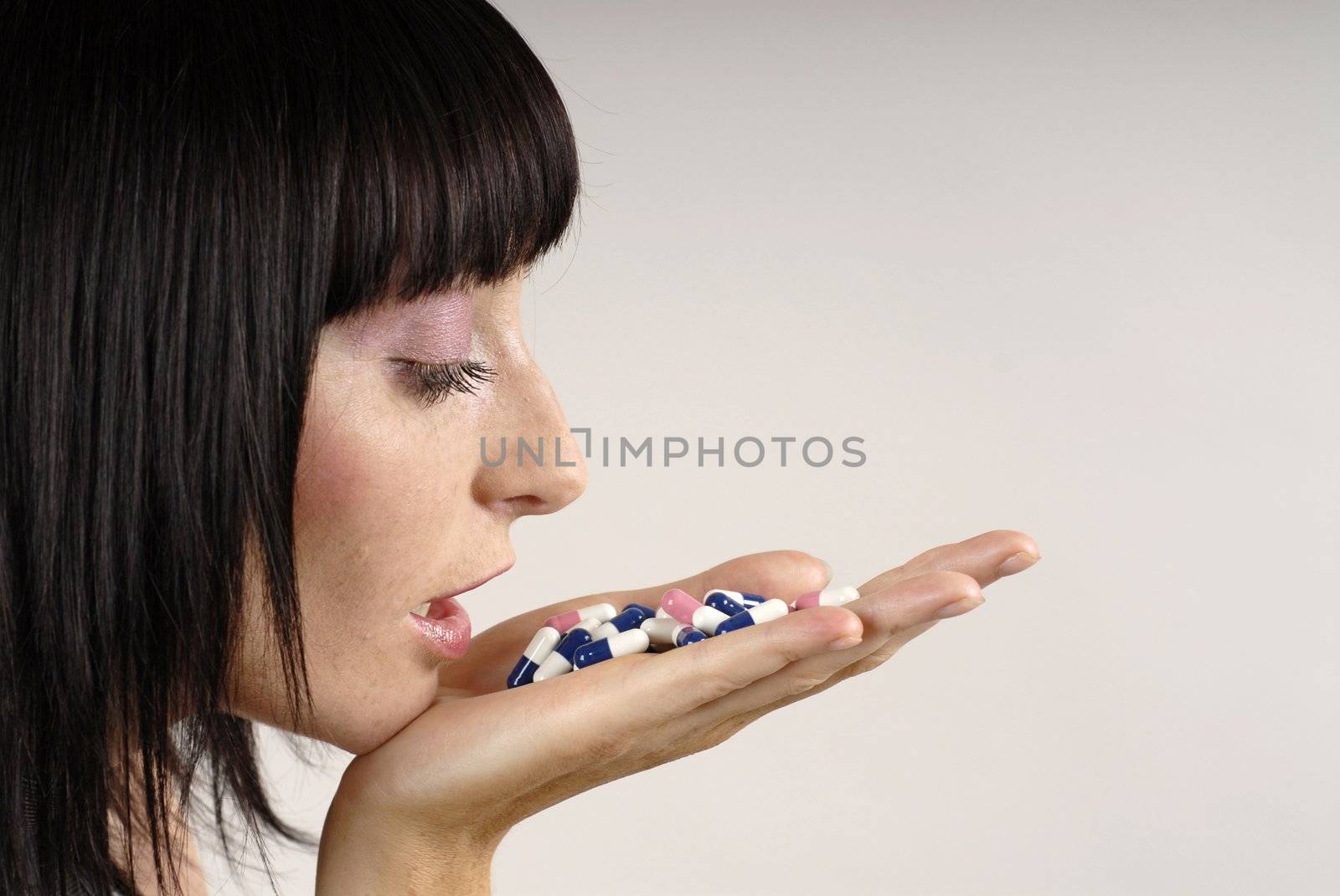 Young woman with colours pills