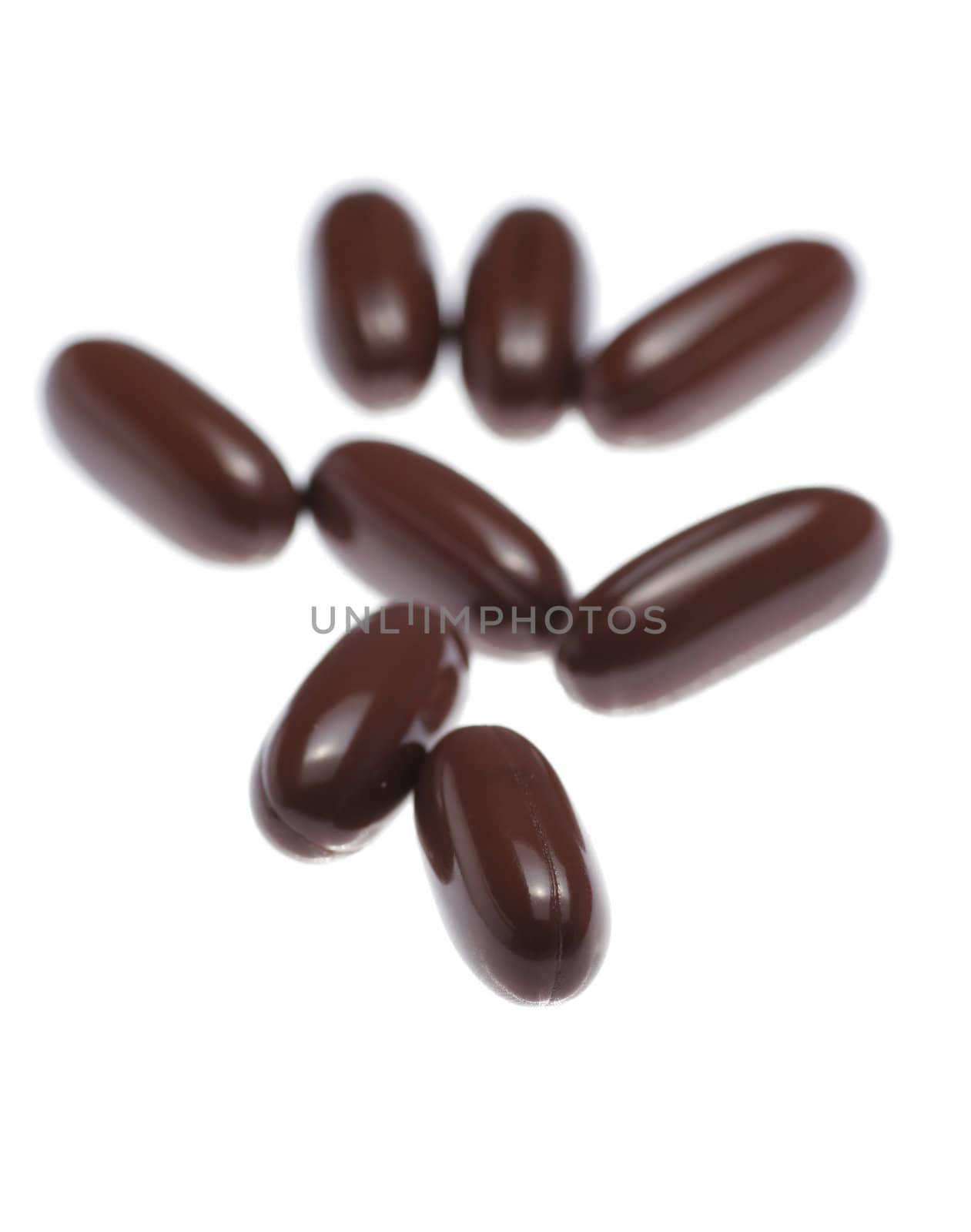 Brown Pills On White Background, Close-Up Shot, Focus On Front