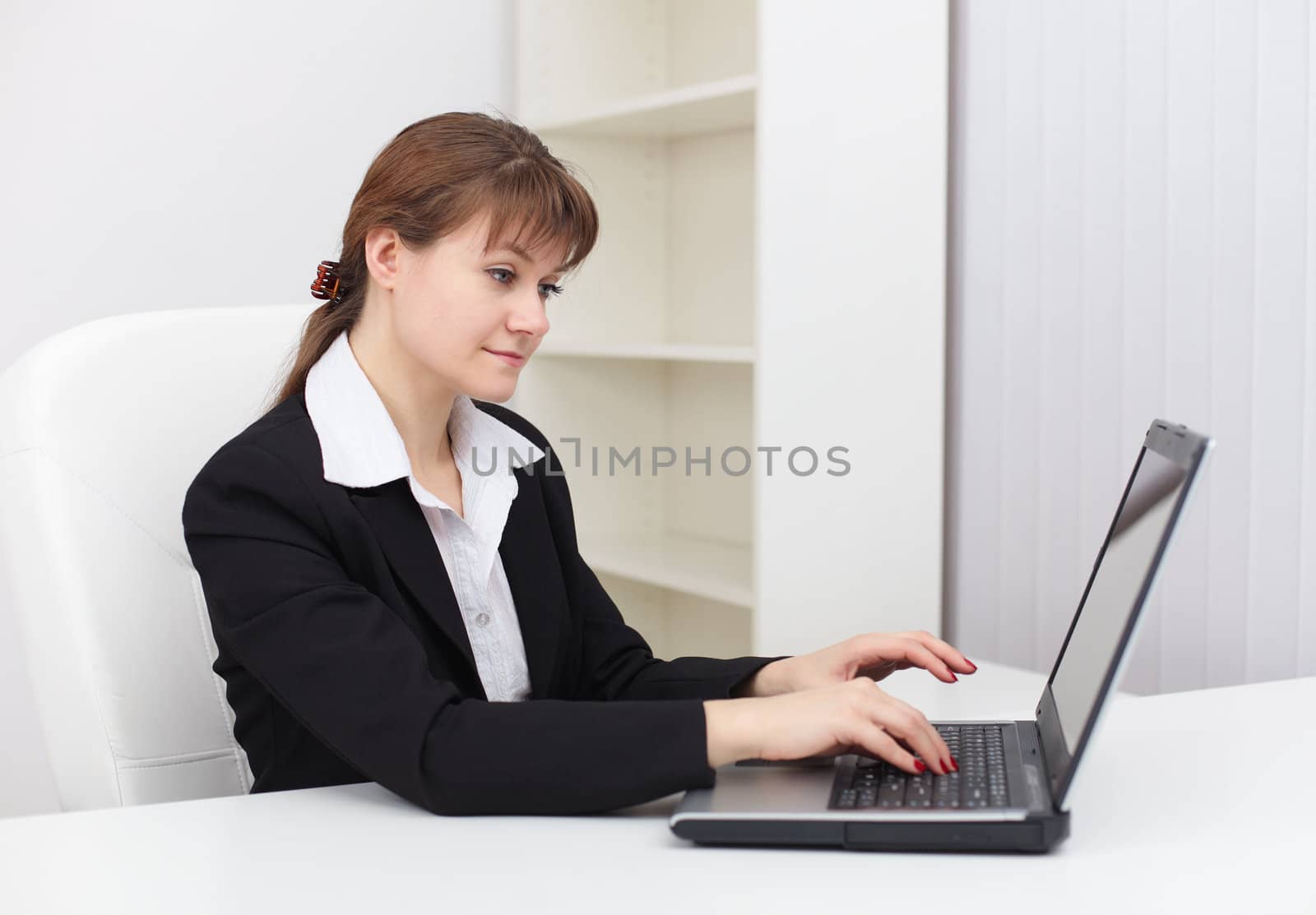 Young tired woman working in an office with computer