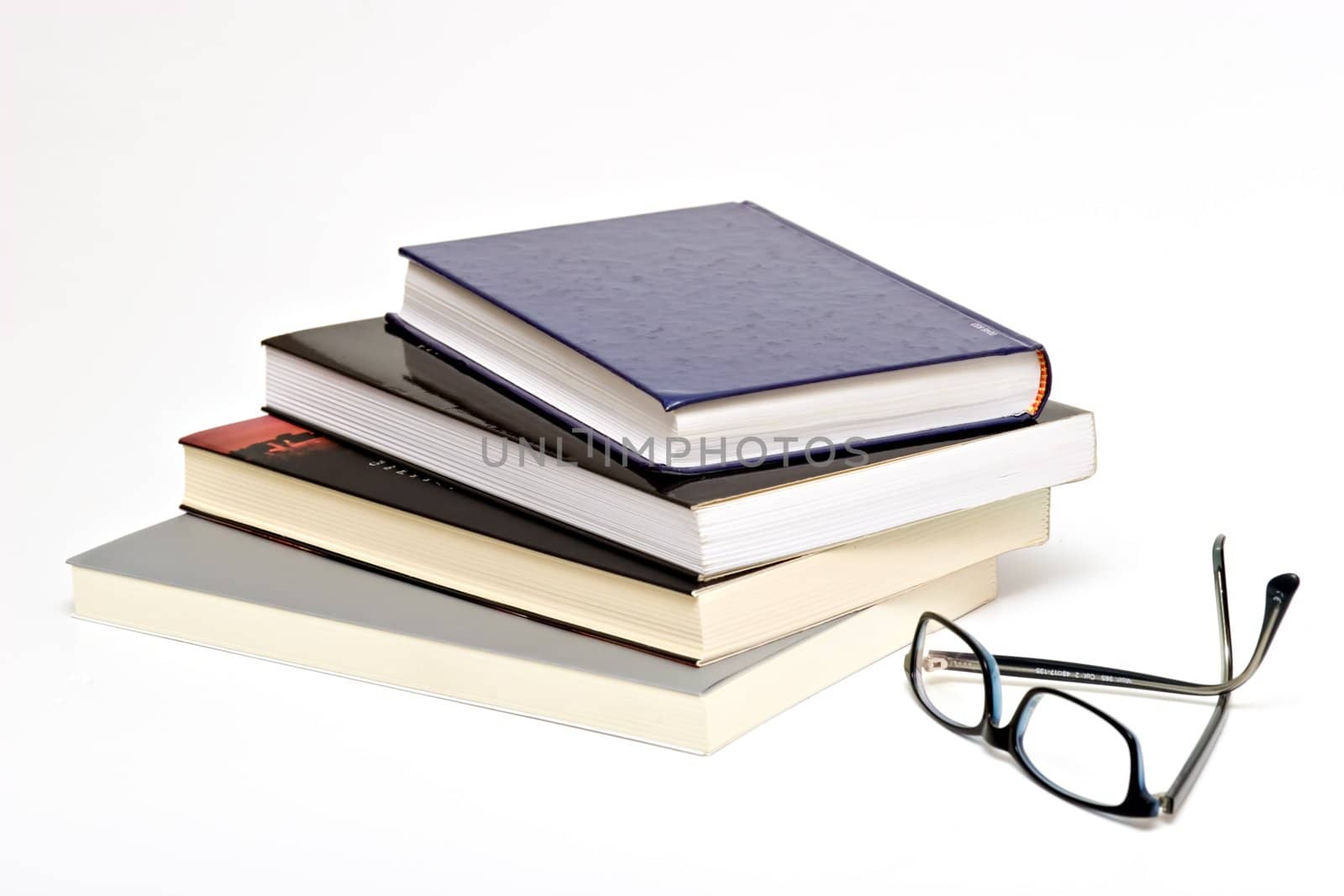 Books and reading glasses on white background