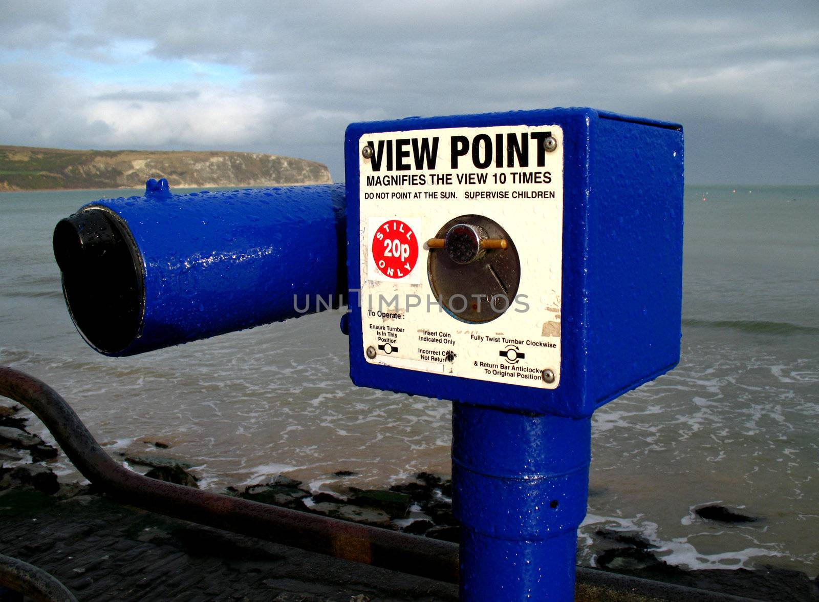 Bright blue telescope spattered in rain drops after heavy rainstorm