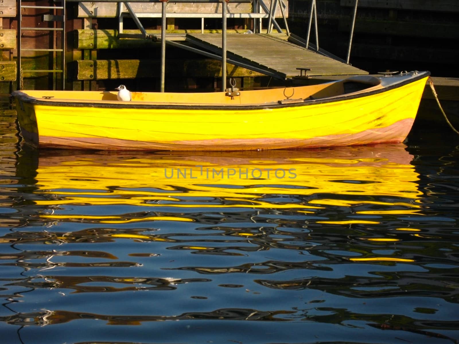A yellow boat by a jetty