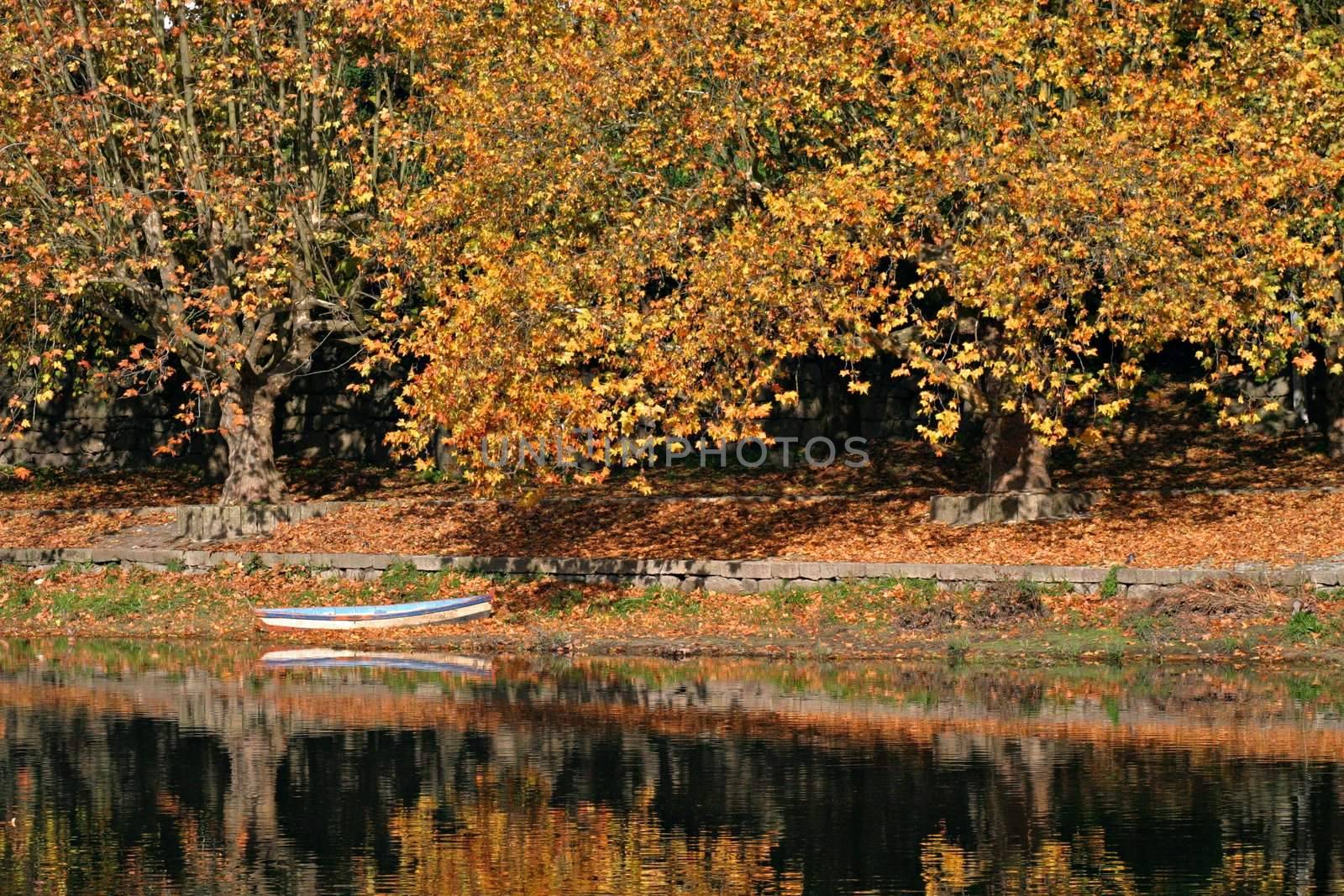 Boat on calm river with autumn colors.