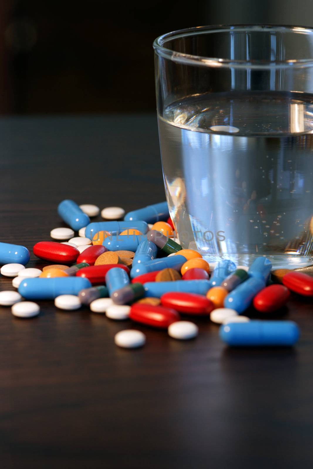 Pills and glass of water by sumners