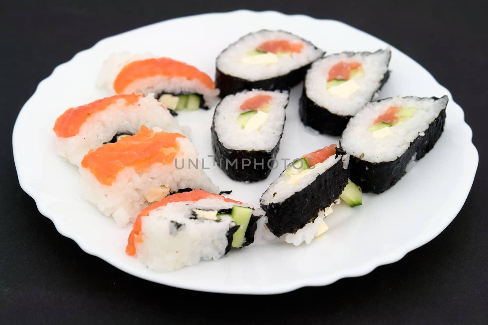 japanese sushi on a white plate on a black background