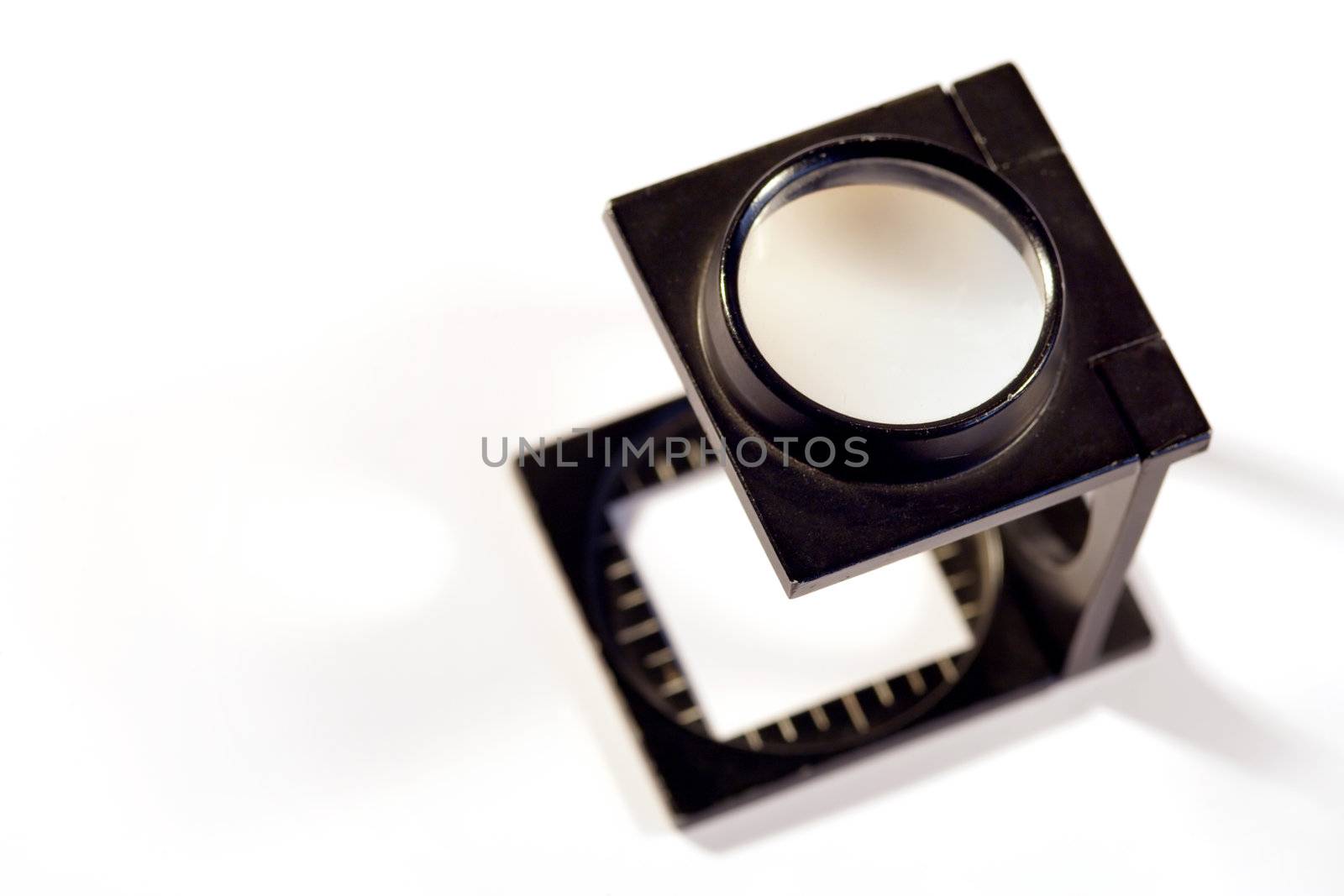 Shallow depth of field image of a Printers loupe on white background.
