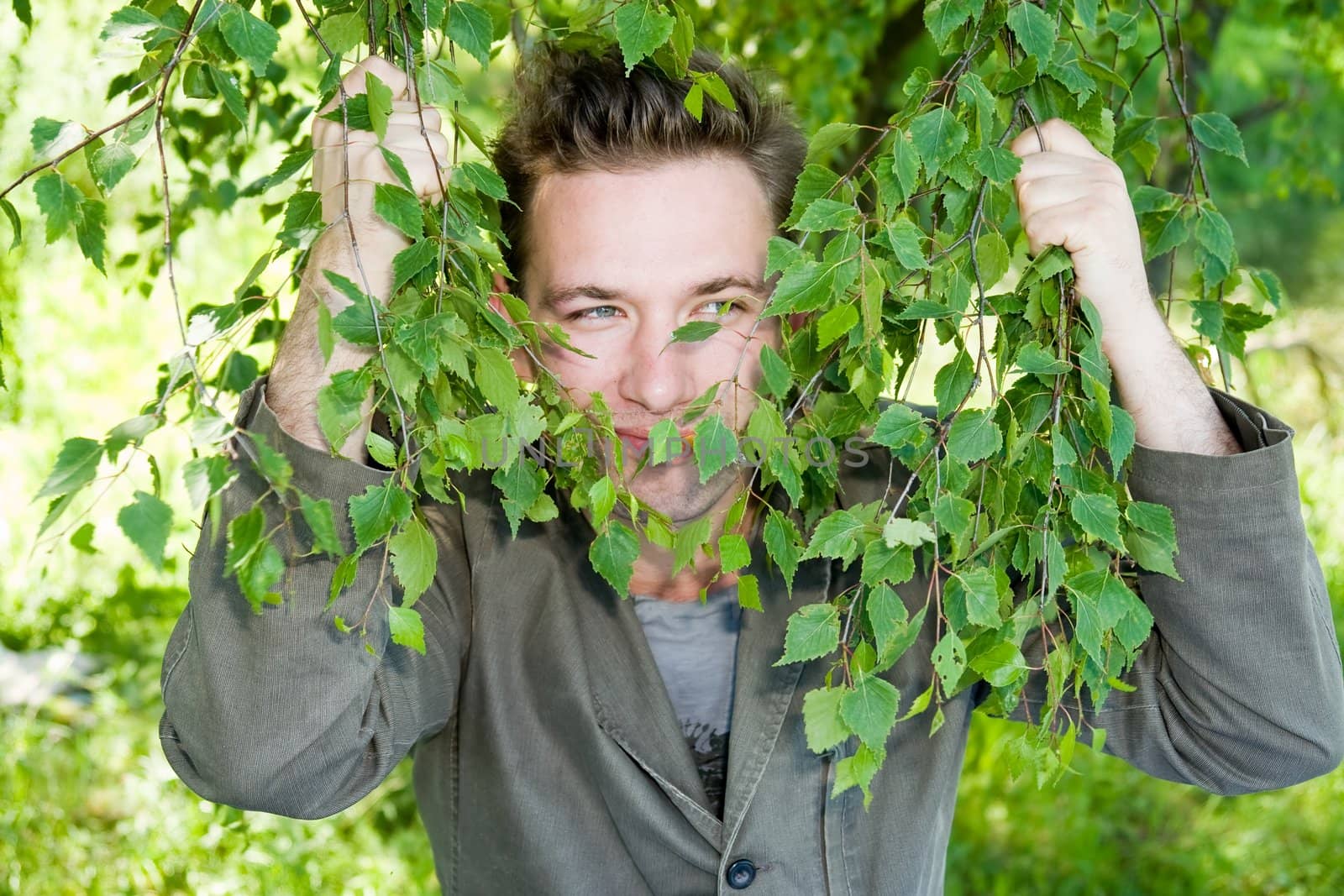 young man in green branches