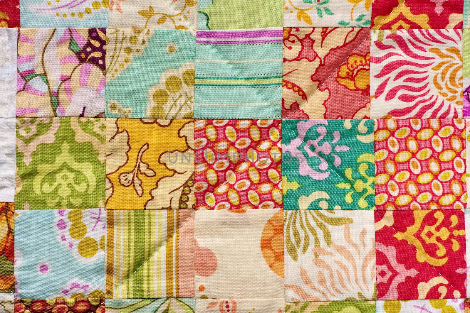 Detail from a handmade patchwork quilt made with squares.