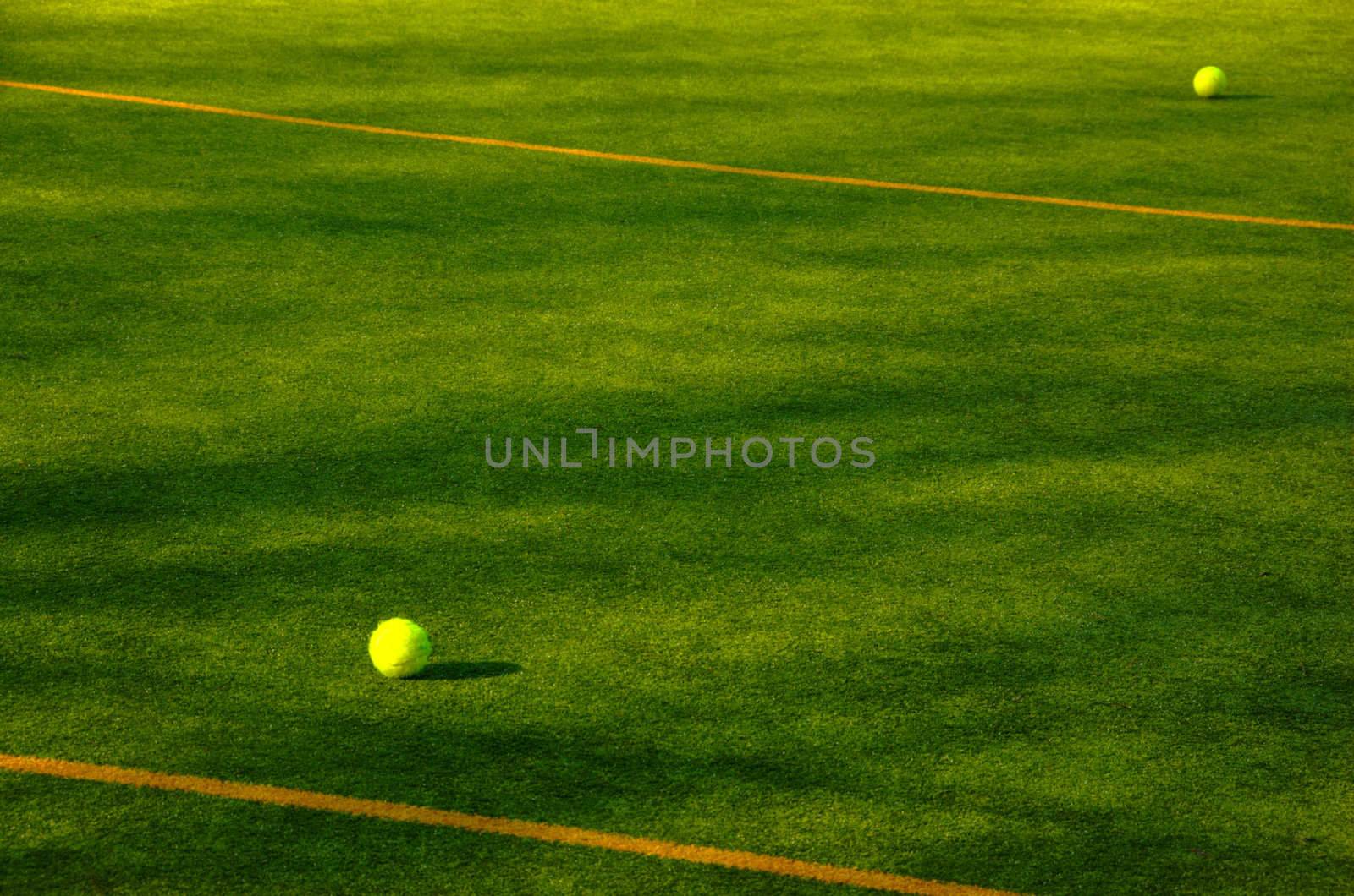 two tennis balls on green tennis court