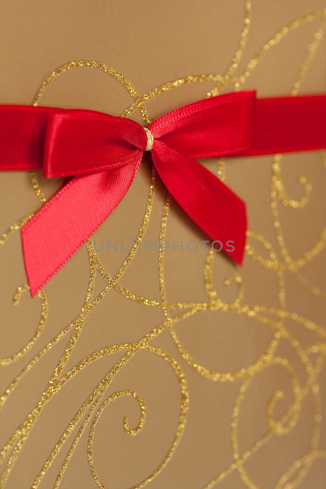 Detail of gold wrapped present with red bow decoration