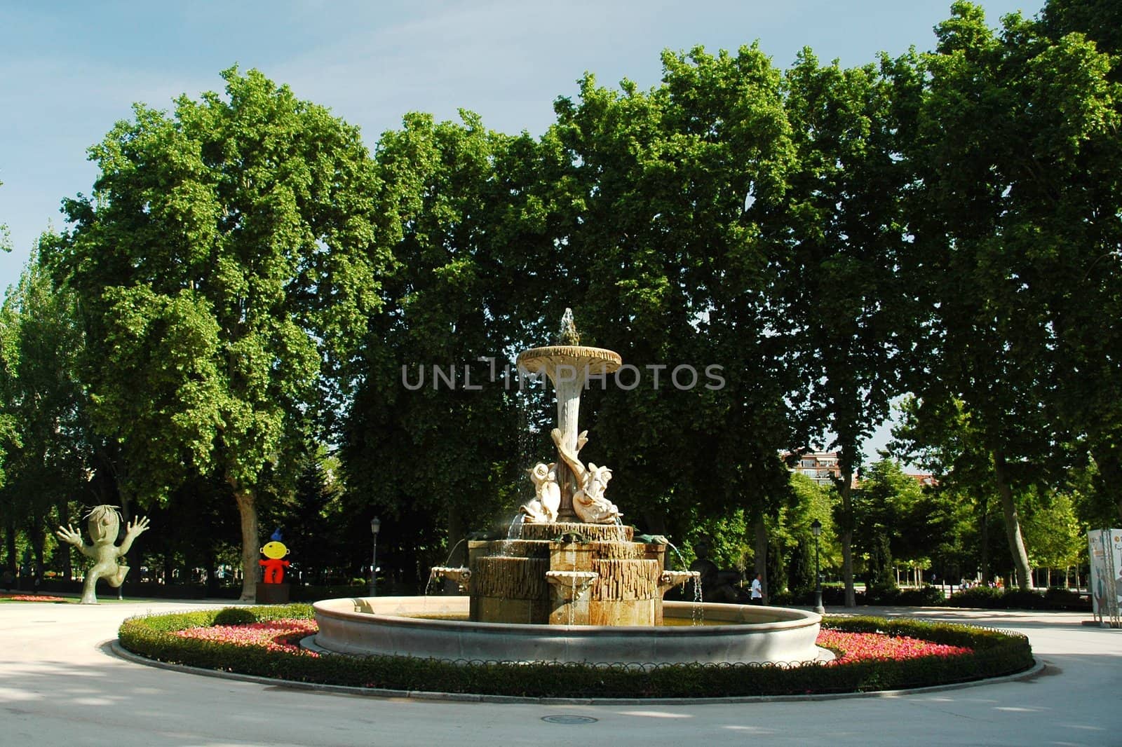 fountain in madrid park with trees and blue sky