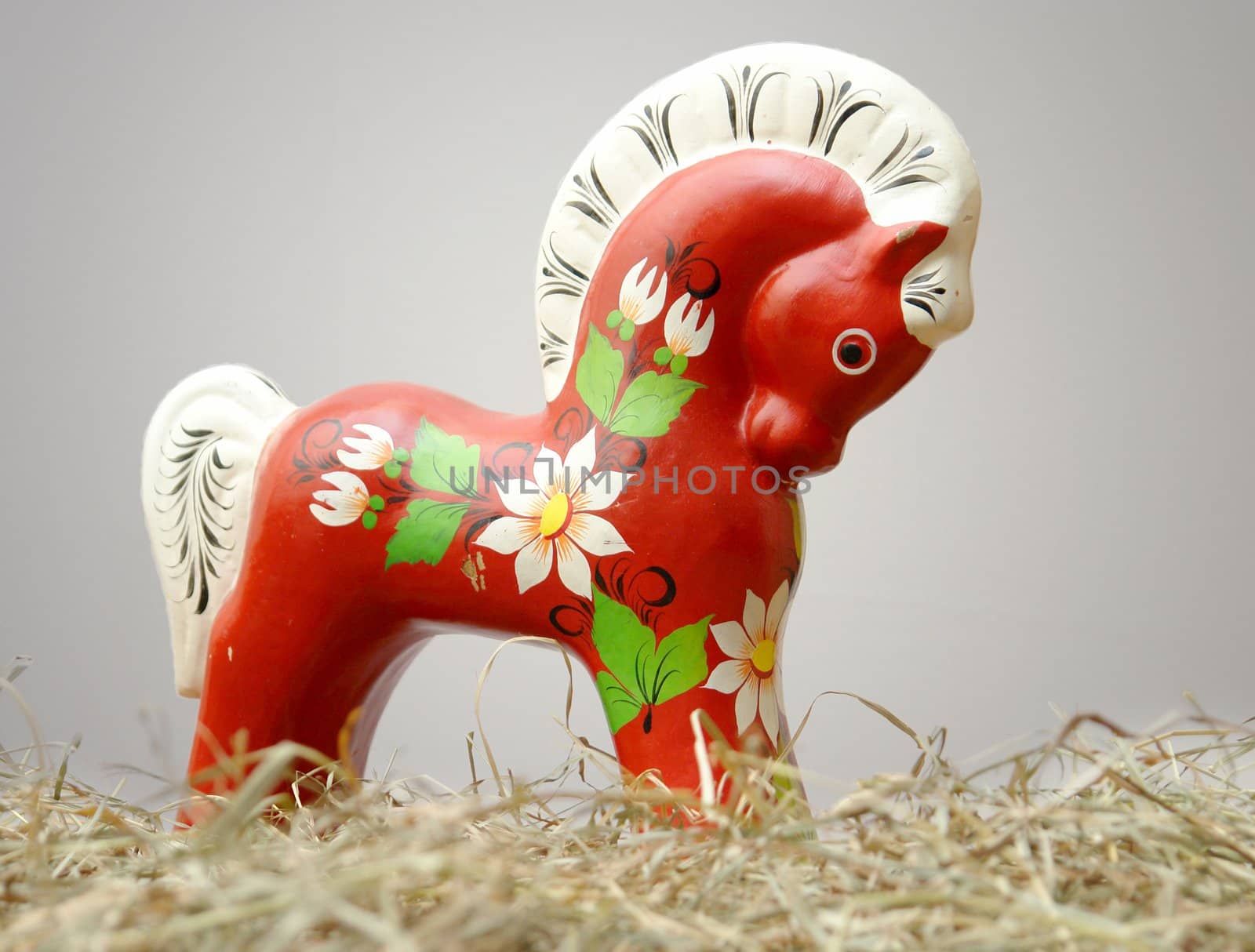 Hohloma horse stasnding in hay on a white background