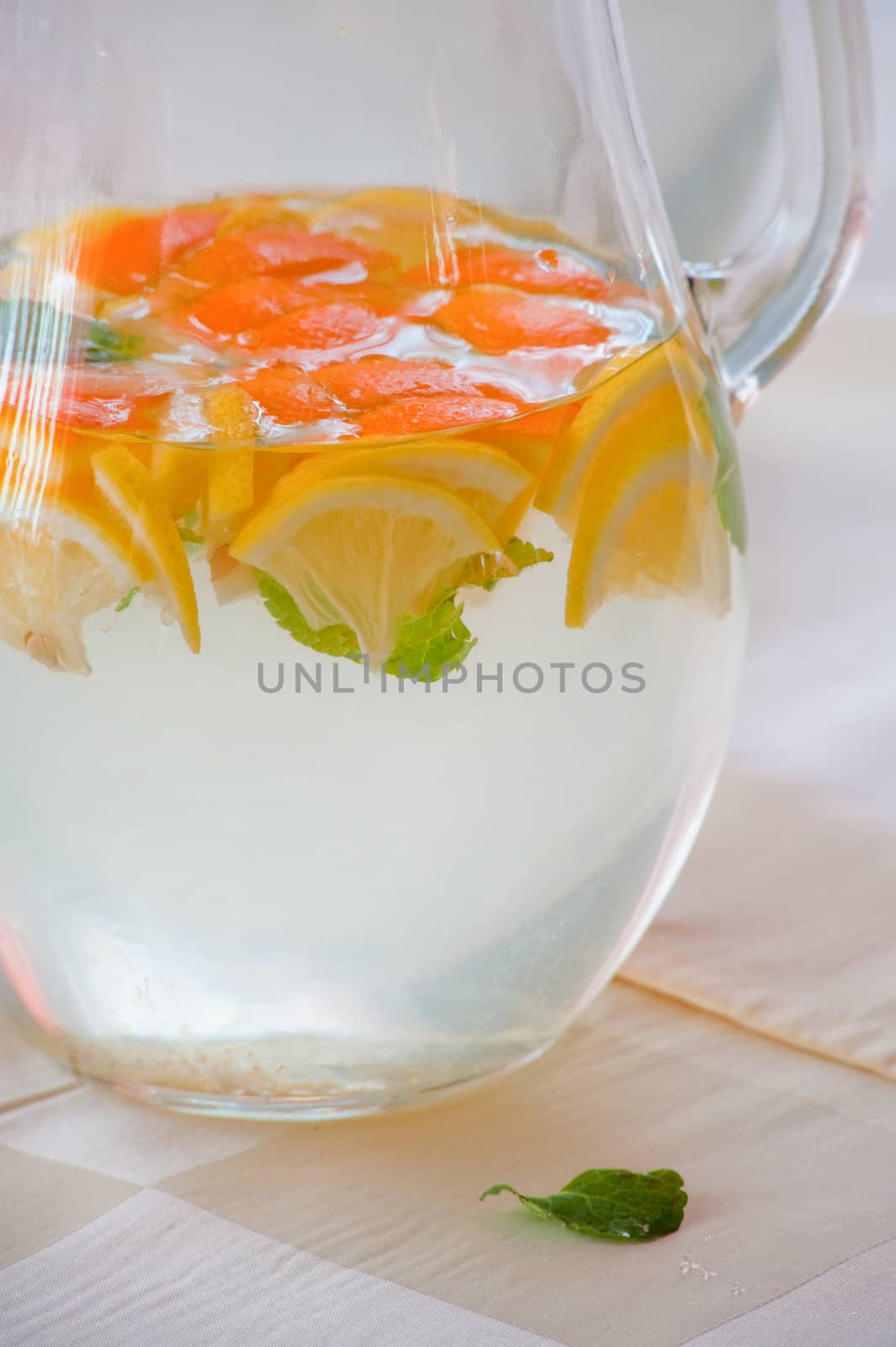 Jug of cold water with lemon and orange slices