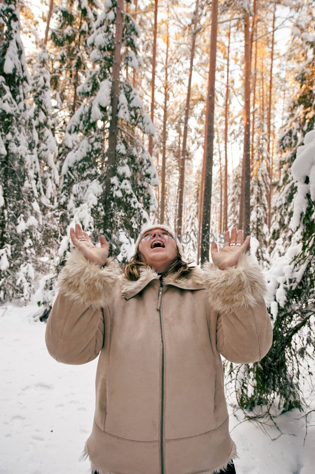 Happy middle-aged women having fun on winters day in forest.