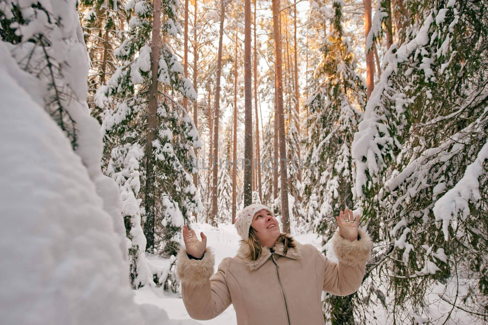 Happy middle-aged women having fun on winters day in forest.